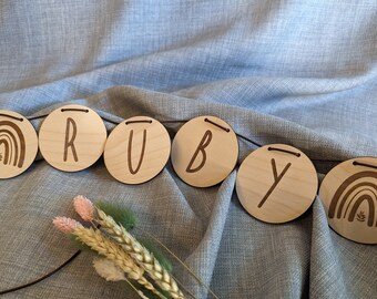 Personalized wooden garland with name and leather cord, 7 cm diameter.