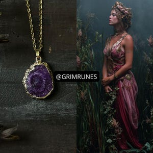Pode incluir: Um colar de corrente dourada com um grande pingente irregular de pedra preciosa roxa. O pingente tem uma borda dourada. A imagem também apresenta uma mulher em um vestido rosa e um adorno floral, em pé na grama alta. O texto "@GRIMRUNES" é visível.