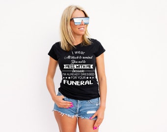 Könnte beinhalten: Ein schwarzes T-Shirt mit weißem Text, der lautet: "Ich trage Schwarz, um dich daran zu erinnern, dich nicht mit mir anzulegen, weil ich schon für deine Beerdigung angezogen bin."