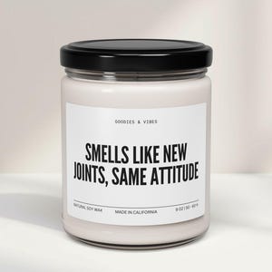 Könnte beinhalten: Ein Glas-Kerze mit schwarzem Deckel. Das Etikett lautet "GOODIES & VIBES" und "SMELLS LIKE NEW JOINTS, SAME ATTITUDE." Die Kerze besteht aus natürlichem Sojawachs und wiegt 255 g. Hergestellt in Kalifornien.
