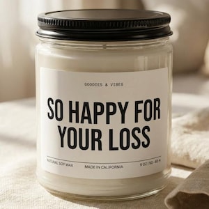 Puede incluir: Vela en tarro de cristal transparente con tapa negra. La etiqueta dice "GOODIES & VIBES" y "SO HAPPY FOR YOUR LOSS". La vela está llena de cera blanca. Peso: 255 g.