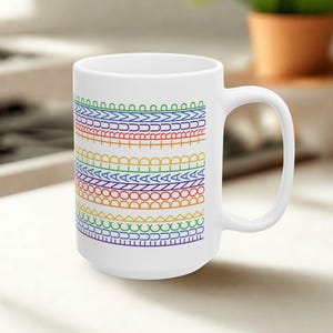 May include: White ceramic mug with a colorful rainbow pattern. The design features horizontal bands of various shapes and colors, including red, orange, yellow, green, blue, and purple. The mug has a large handle.