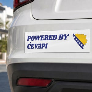 Peut inclure: Autocollant rectangulaire blanc avec le texte bleu "POWERED BY ĆEVAPI" et une carte jaune et bleue de la Bosnie-Herzégovine. L'autocollant est apposé à l'arrière d'une voiture blanche.