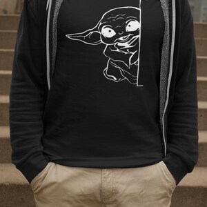May include: A black t-shirt with a white graphic of a character from the Star Wars franchise peeking around a corner.