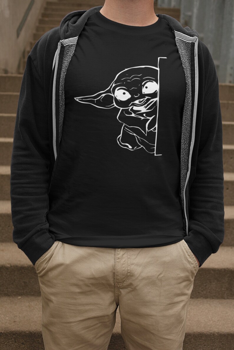 May include: A black t-shirt with a white graphic of a character from the Star Wars franchise peeking around a corner.