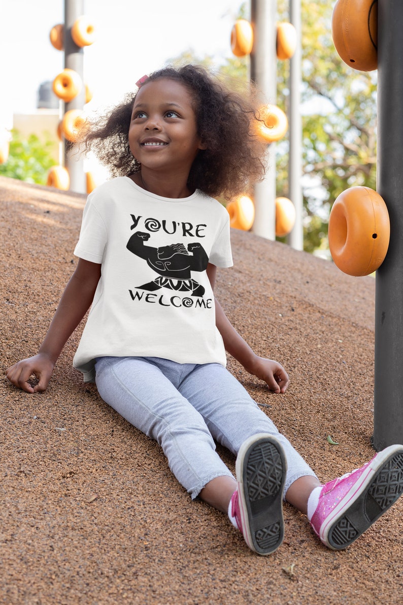 May include: A white t-shirt with a black graphic of a cartoon character with the text "YOU'RE WELCOME" on it. The character is flexing its muscles.