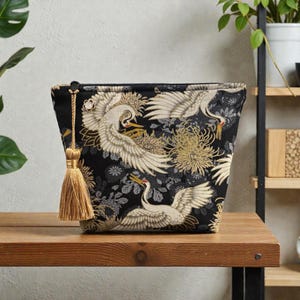 May include: A set of three ceramic mugs with a speckled, matte finish in cream, light grey, and dark grey. Each mug has a simple, modern design and a rounded handle.