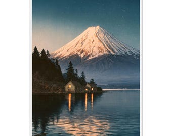 May include: A vertical art print depicting a snow-capped mountain peak illuminated by soft light at twilight. Below, small cabins with glowing windows sit along a dark shoreline, reflecting into the calm, deep blue water of a lake.