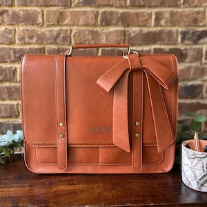 Brown laptop bag for women with custom bow detail. Leather laptop bag for her with laser engraved monogrammed initials on front. Custom computer bag for her. Custom tan leather briefcase for professional woman. Personalized leather work bag women.