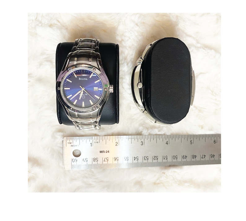 Close up view of individual watch pillows that come with men's watch display case. Watch pillows are black faux leather and 2 inches wide.