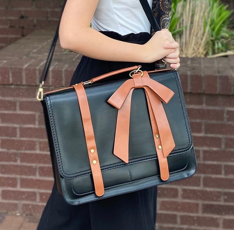 Young woman modeling black and brown laptop bag. Feminine laptop bag with bow. Professional computer work bag for woman laptop compartment. Monogrammed briefcase for woman. Custom graduation gift for daughter. New job gift for woman. Promotion gift