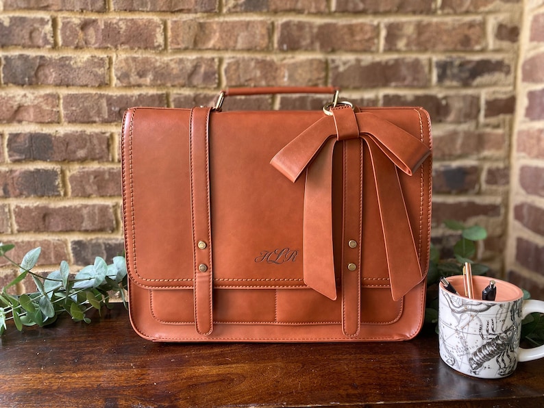 Brown laptop bag for women with custom bow detail. Leather laptop bag for her with laser engraved monogrammed initials on front. Custom computer bag for her. Custom tan leather briefcase for professional woman. Personalized leather work bag women.