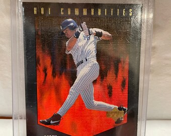 May include: A baseball card featuring Derek Jeter, a New York Yankees shortstop. The card is from the "Hot Commodities" series and features a red and black background with a gold border.
