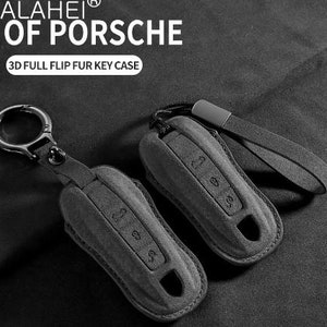 May include: Gray key fob case with a leather strap and metal keyring. The case has embossed buttons and a keyhole cutout. The text "SALAHEI OF PORSCHE" and "3D FULL FLIP FUR KEY CASE" are visible.