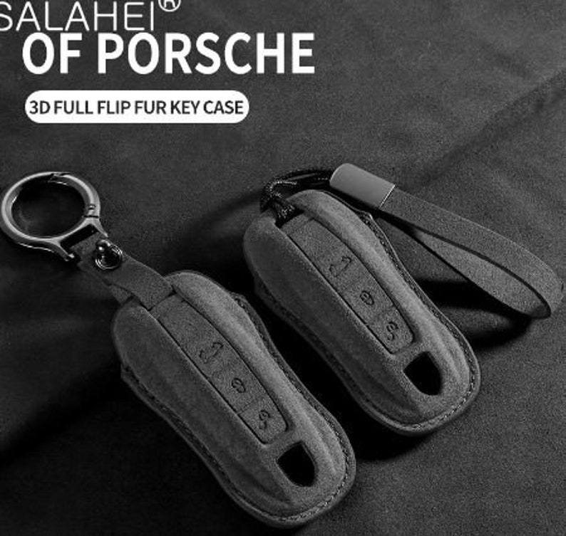 May include: Gray key fob case with a leather strap and metal keyring. The case has embossed buttons and a keyhole cutout. The text "SALAHEI OF PORSCHE" and "3D FULL FLIP FUR KEY CASE" are visible.