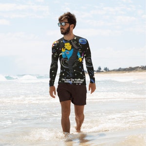 Puede incluir: Una camiseta negra de manga larga con un estampado gráfico colorido de un personaje de dibujos animados con una camisa azul y un fondo negro. La camiseta tiene el texto "To not use that trap would be illogical" impreso en la parte delantera.