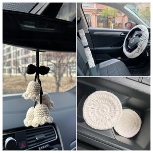 May include: White crocheted car accessories including a steering wheel cover, seatbelt cover, and two small round coasters. The coasters are in the car's door compartment. There is also a white crocheted flower-shaped car charm hanging from the rearview mirror.