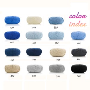 Op de afbeelding: Kleurenindexkaart met 16 verschillende garenkleuren in bollen. De kleuren omvatten blauw, lichtblauw, beige, grijs, zwart en donkerblauw.
