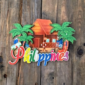 May include: A colorful wooden souvenir magnet featuring a tropical hut, palm trees, and the word "Philippines".