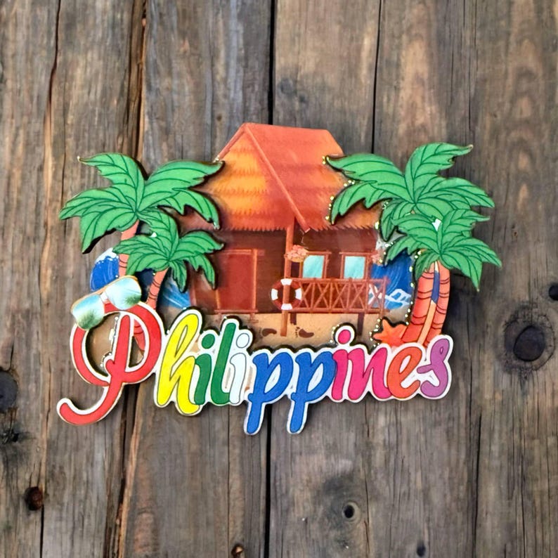 May include: A colorful wooden souvenir magnet featuring a tropical hut, palm trees, and the word "Philippines".