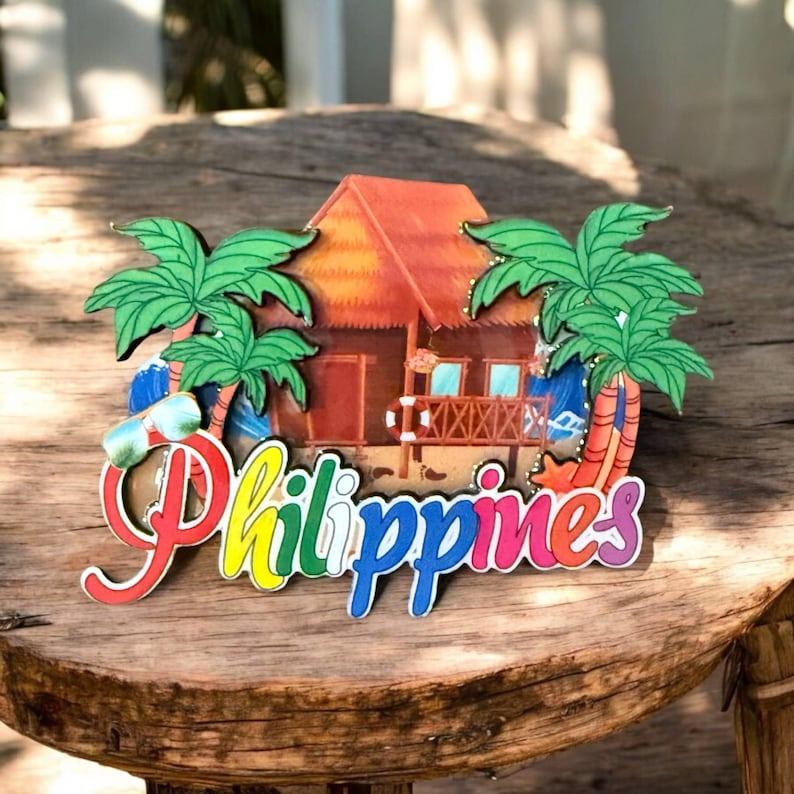 May include: A colorful wooden souvenir from the Philippines featuring a beach hut, palm trees, and the word "Philippines" in rainbow letters.