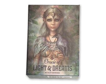 May include: A boxed set of oracle cards titled "Oracle of Light & Dreams" by Scot Howden. The box features a watercolor illustration of a woman with long hair, pointed ears, and a raven. The text is in a stylized font.