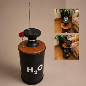May include: A black cylindrical water dispenser with a wooden top and a silver faucet. The base features the white text H2O. A single red rose is placed in a small circular opening on the wooden surface. The unit is designed for water jugs.