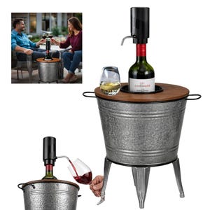 May include: A white ceramic mug with a black handle and the text "But First, Coffee" in a bold, black font. The mug is set against a blurred background, suggesting a cozy setting.