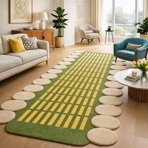 Puede incluir: Una alfombra rectangular verde y amarilla con un patrón de rectángulos amarillos. La alfombra está rodeada de piedras circulares beige. La alfombra está en un salón con un sofá, sillas y plantas.