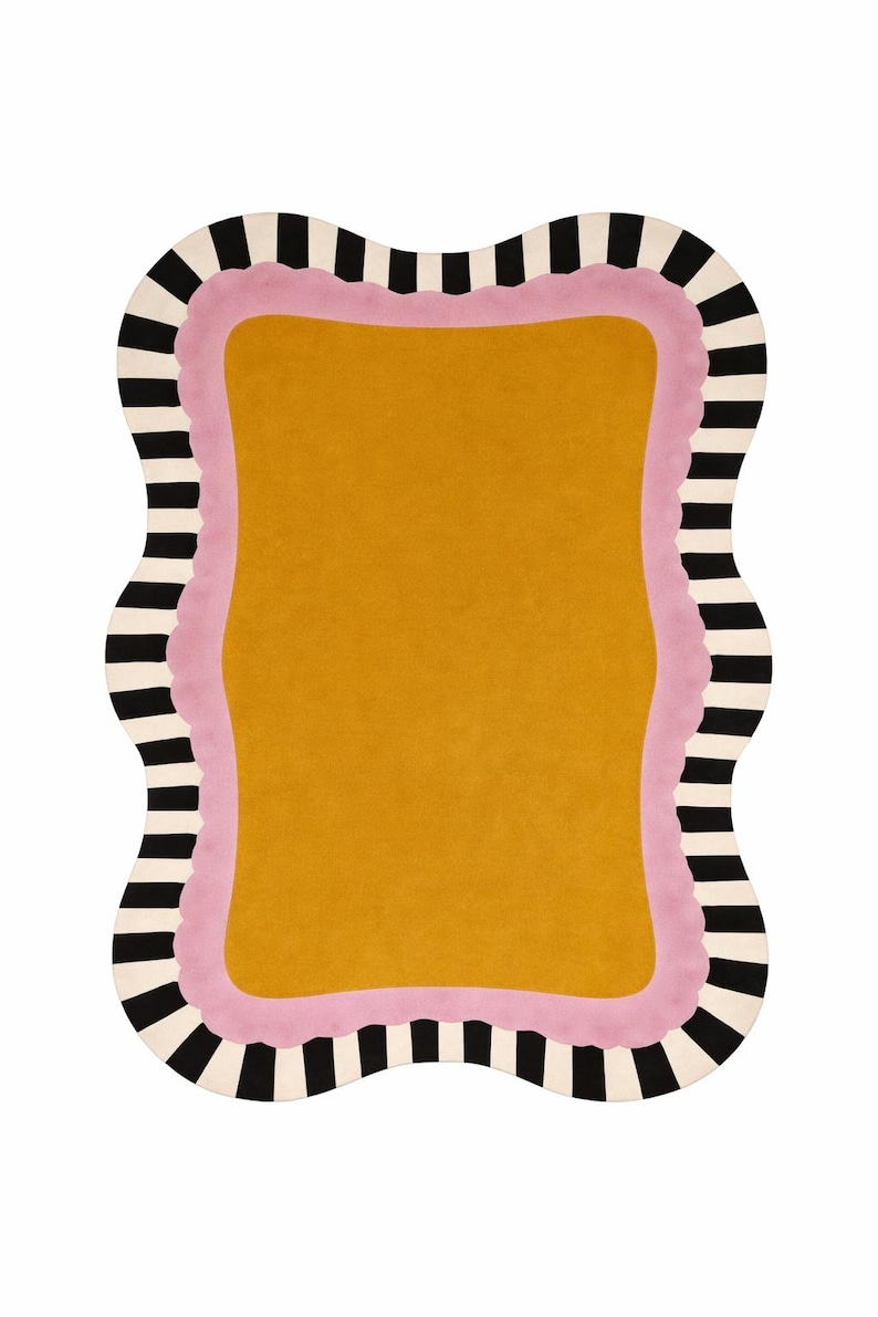 May include: A mustard yellow rug with a wavy, irregular border. The rug has a pink inner border and a black and white striped outer border. The rug is a decorative floor covering.
