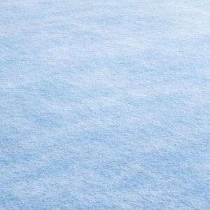 May include: A large, rectangular area rug in a soft, light blue color. The rug has a plush, textured surface, creating a comfortable and inviting look. The rug is suitable for living rooms, bedrooms, or other spaces.