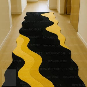 May include: A modern, wavy-patterned rug in black and yellow. The rug's design features flowing, organic shapes that create a visually dynamic floor covering. The rug is placed in a hallway with light-colored walls and flooring.
