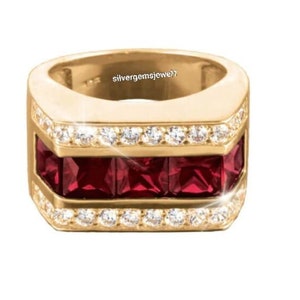 Puede incluir: Un anillo dorado con un diseño rectangular. El anillo presenta una fila de piedras preciosas cuadradas de color rojo intenso y un borde de pequeñas piedras preciosas transparentes. El texto "silvergemsjewel1" es visible en el anillo.