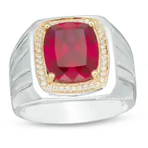 Puede incluir: Un anillo de plata y oro con una gran piedra roja de talla cojín rodeada de piedras blancas más pequeñas.