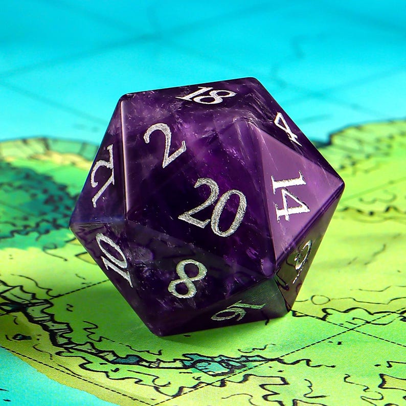 May include: A purple 20-sided die with silver numbers. The die is made of amethyst and has a faceted shape.