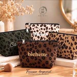 May include: Four corduroy zipper pouches featuring leopard print patterns in olive green, cream, tan, and brown. Each pouch is personalized with text including Maman, bichette, and ROAR. The pouches have black zippers and silver-toned metal zipper pulls.