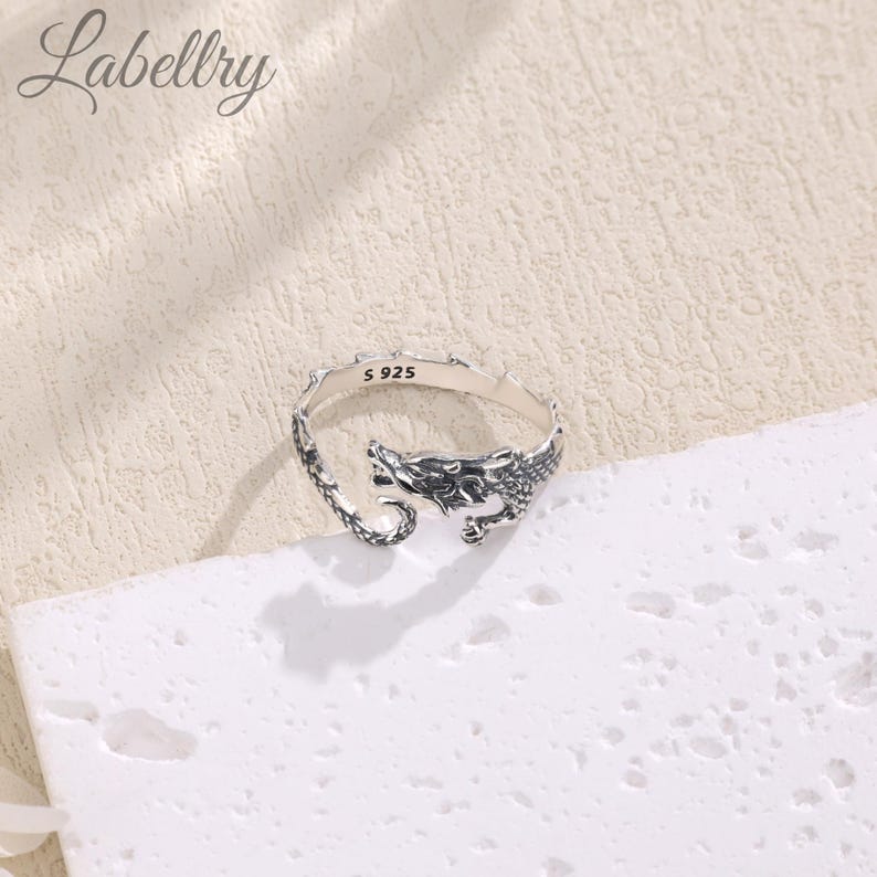 May include: Silver dragon ring with a detailed design. The ring is marked with "S 925" on the inside.