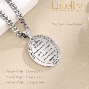Pu&ograve; includere: Una collana con pendente di San Michele argentato. Il pendente ovale, largo 22 mm e alto 37 mm, presenta la scritta "SAINT MICHAEL PROTECT US" e una preghiera. La collana ha una catena spessa.