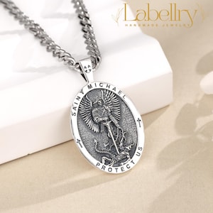 Pu&ograve; includere: Collana color argento con un ciondolo ovale raffigurante San Michele. Il ciondolo reca la scritta "SAINT MICHAEL PROTECT US". La catena &egrave; a maglia grossa. Gioielli del marchio Labellry.
