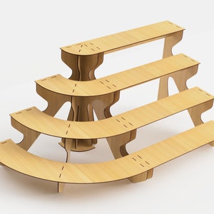 May include: A tiered display stand made of light-colored wood. The stand has four curved shelves of varying sizes, supported by a central structure and angled legs. The design is modern and minimalist, suitable for showcasing products.