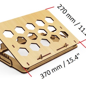 Pode incluir: Suporte para laptop de madeira com design de favo de mel. O suporte mede 370 mm de largura e 270 mm de altura.