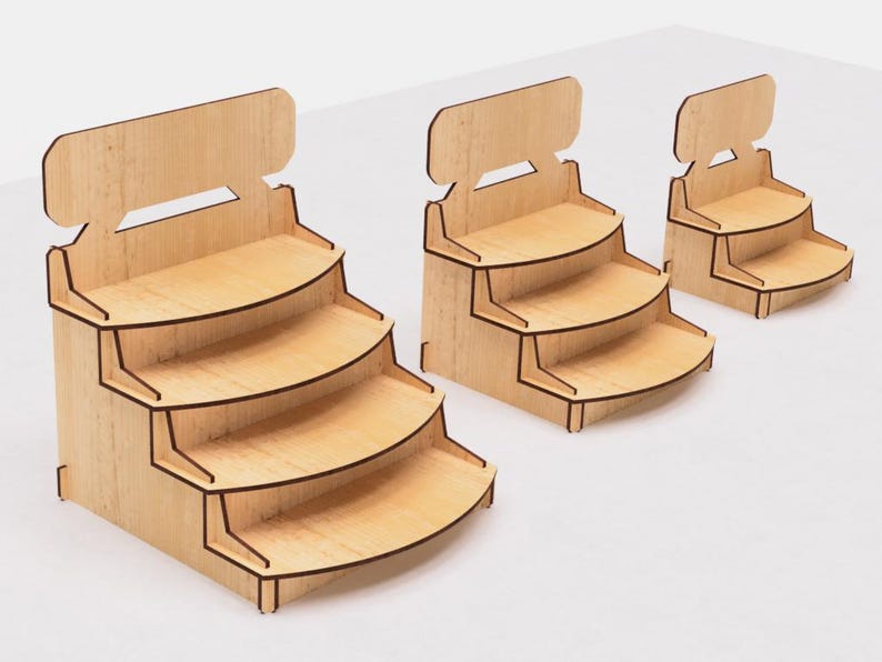 May include: Three wooden display stands with four shelves each. The stands are made of light brown wood and have a simple, modern design. The shelves are curved and have a slight lip to prevent items from falling off.