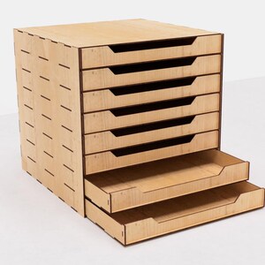 May include: A wooden drawer organizer with eight drawers. The drawers are made of light wood and have a natural finish. The organizer is perfect for storing small items like jewelry, craft supplies, or office supplies.