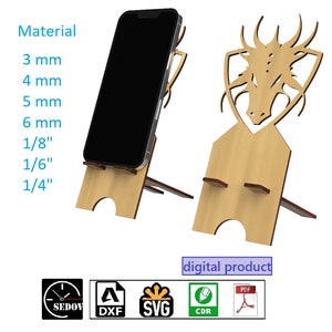 Könnte beinhalten: Ein digitaler Download eines Handyständer-Designs mit einem Drachenkopf. Das Design ist in den Formaten DXF, SVG, CDR und PDF verfügbar. Der Ständer kann aus Holz mit einer Dicke von 3 mm, 4 mm, 5 mm, 6 mm, 1/8 Zoll, 1/6 Zoll oder 1/4 Zoll hergestellt werden.