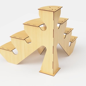 May include: A light-colored wooden display stand with multiple tiers. The stand has a unique, open design with curved edges and cut-out shapes. The tiers are connected by vertical supports, creating a multi-level structure. The stand is made of light-colored wood.