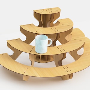 May include: A three-tiered, light-colored wooden display stand with a unique, curved design. The stand features a light blue mug on the middle tier. The stand is made of light-colored wood and has a modern, minimalist aesthetic.