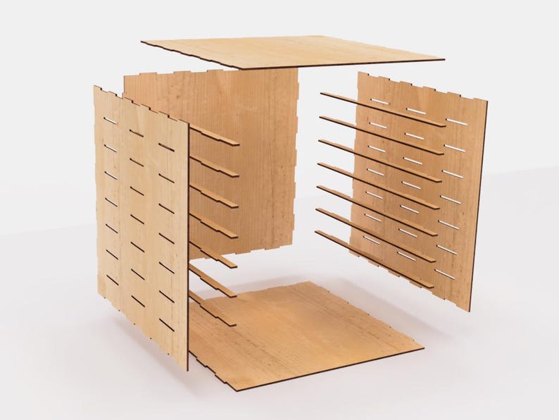 May include: A disassembled wooden cube with a grid pattern on each side. The cube is made of light brown wood and has a natural finish.