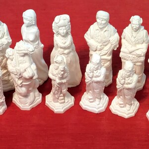 May include: A set of white chess pieces, including a king, queen, rook, bishop, knight, and pawn. The pieces are made of a smooth, white material and have a classic design.