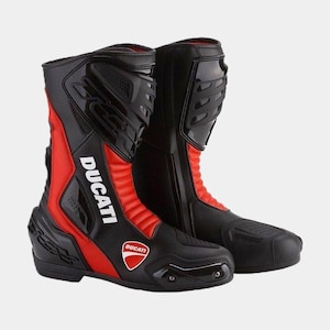 Puede incluir: Botas de moto negras y rojas con el logotipo de Ducati en el lateral. Las botas tienen una cremallera en el lateral y una puntera reforzada.