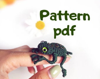 May include: A crochet pattern for a green frog with black spots and green eyes. The pattern is available as a PDF download.